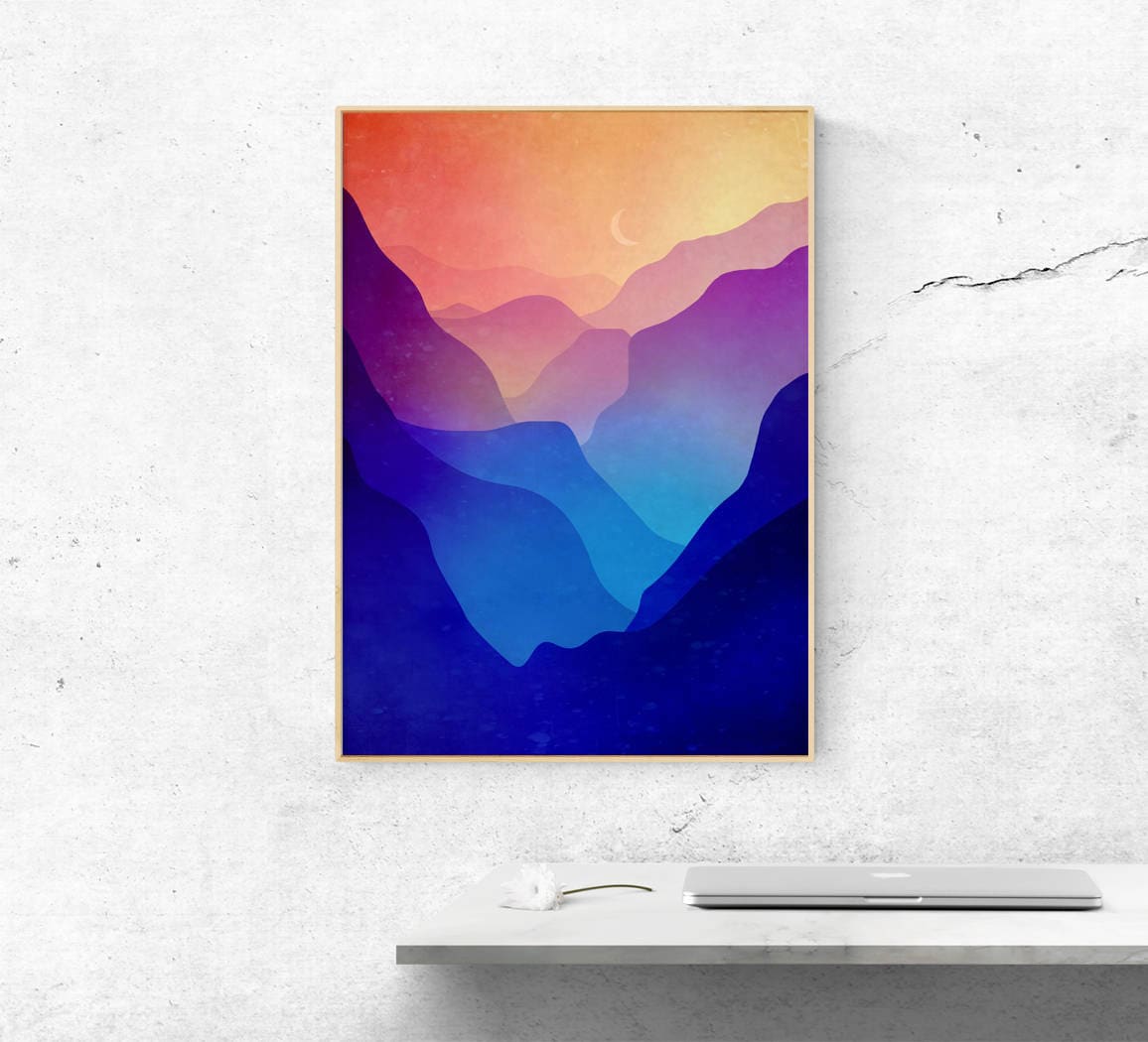 A vertical framed art print featuring a colorful mountain landscape with layered peaks in shades of blue, purple, pink, and orange