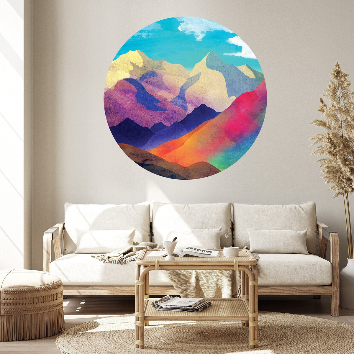A colorful circular watercolor mountain wall decal is displayed on a light beige wall 