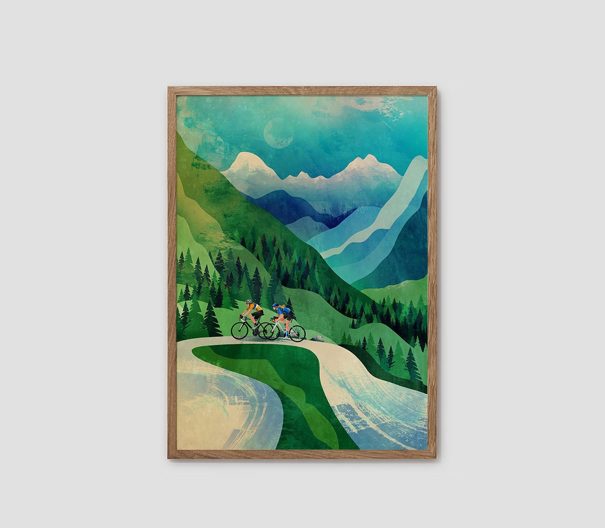 A framed art print depicting a stylized mountain landscape with two cyclists on a winding road, shown against a light gray background.