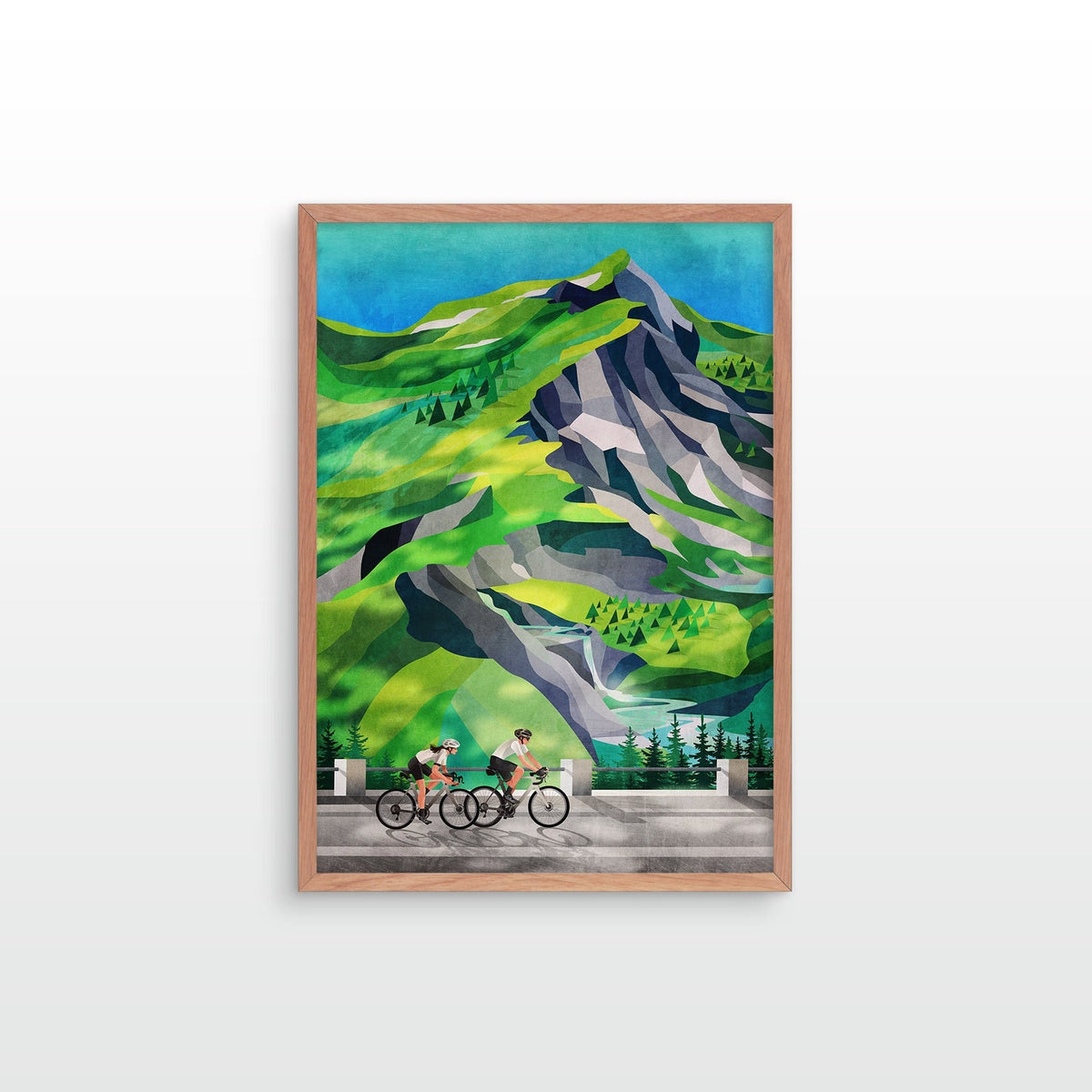 A framed art print featuring a stylized mountain landscape with green hills, gray rock formations, and two cyclists on a road in the foreground, shown against a light gray wall.