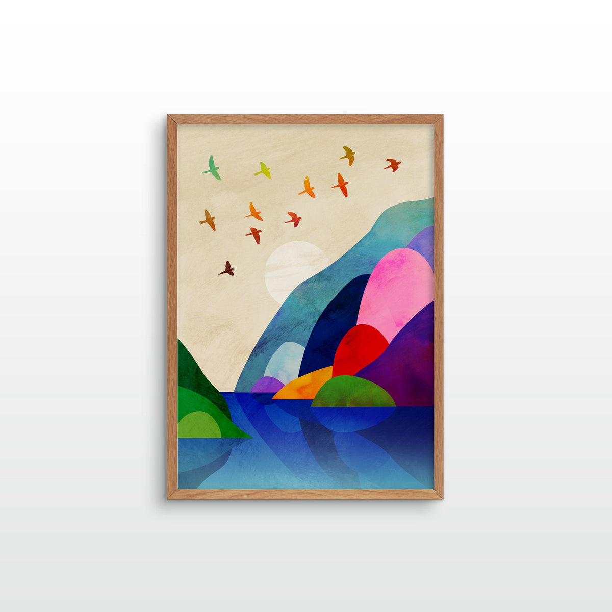 A framed abstract landscape art print featuring colorful geometric hills, birds, and water on a light beige background