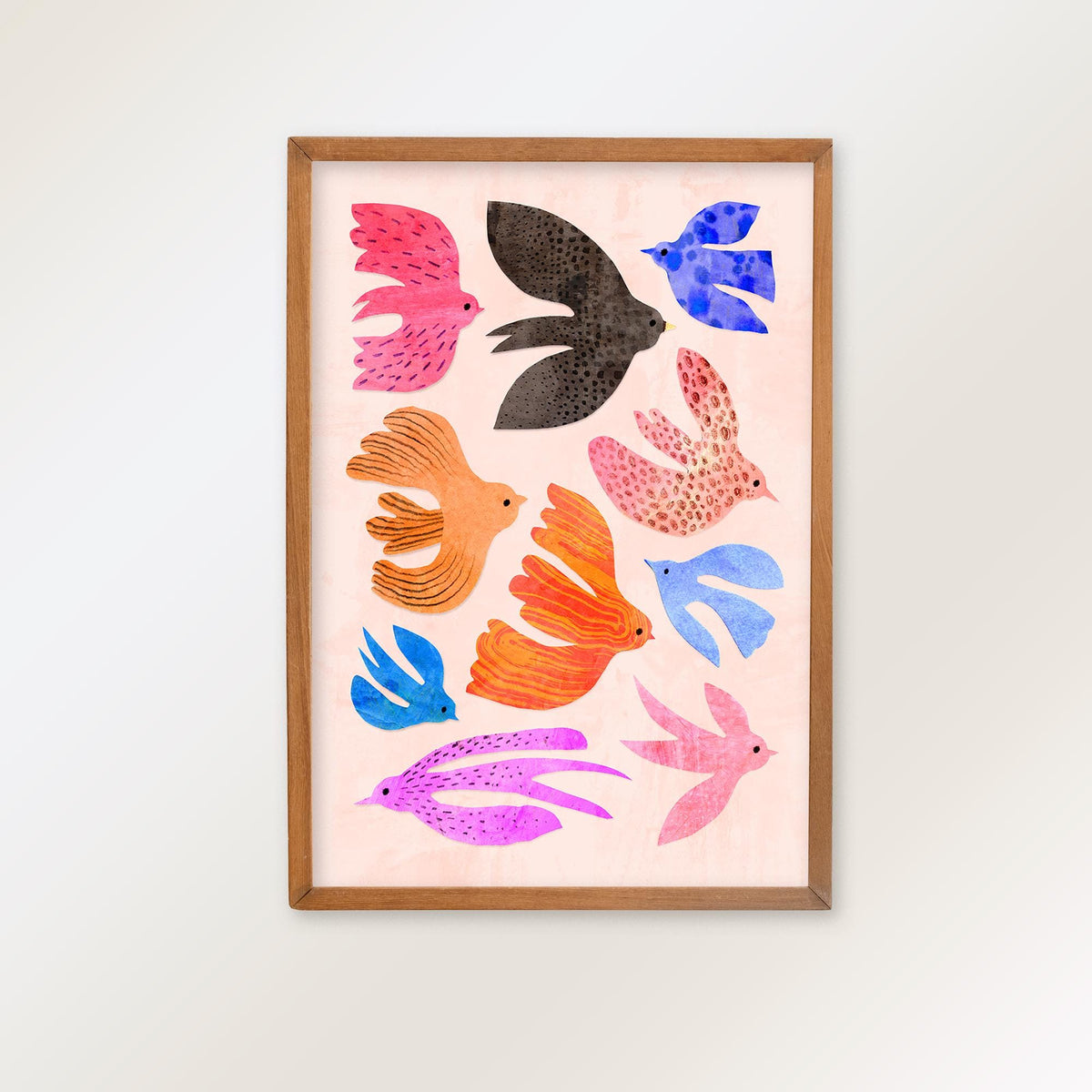 A framed art print featuring a collection of colorful, stylized birds in pink, blue, orange, purple, and black on a pale pink background