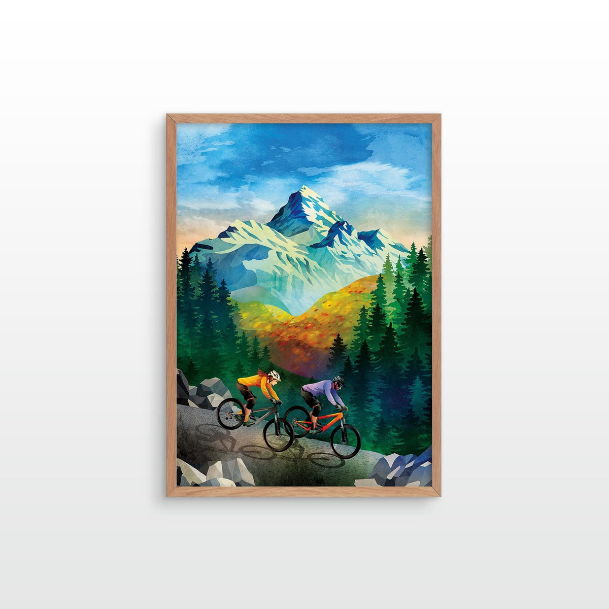 A framed art print featuring a colorful mountain landscape with two mountain bikers in the foreground, displayed against a clean white wall.