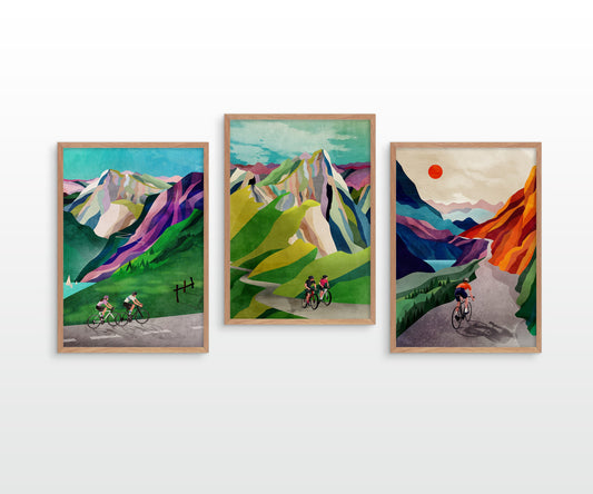 Three framed art prints depicting stylized mountain landscapes with cyclists, displayed side-by-side on a white wall.