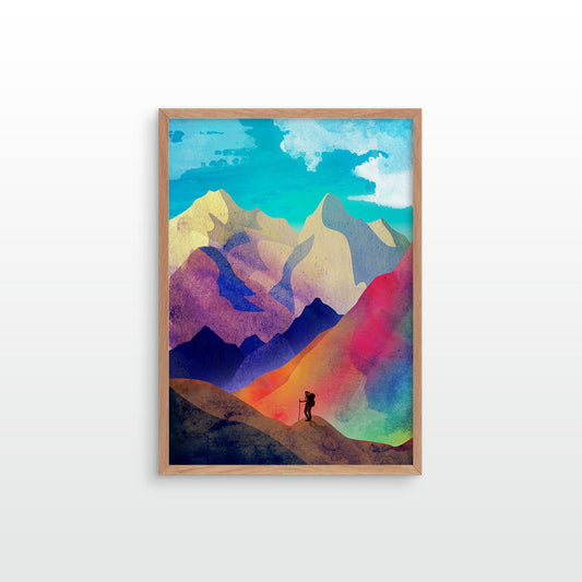 A framed art print featuring a colorful watercolor-style mountain landscape with a small hiker silhouette, shown hanging on a light gray wall.