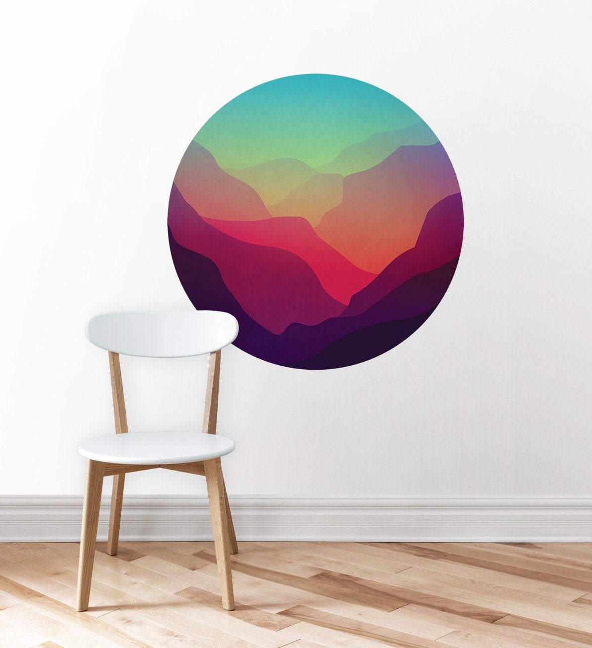 A circular wall decal featuring a colorful abstract mountain landscape in shades of teal, green, yellow, orange, pink, and purple.