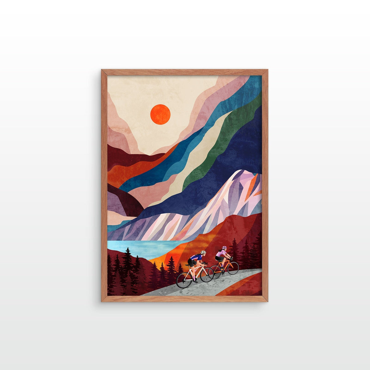 A framed art print featuring a stylized mountain landscape with two cyclists on a road, shown against a light gray background.