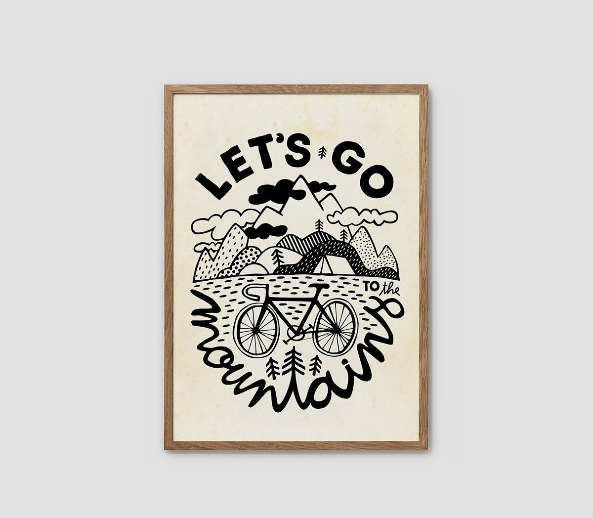 A framed art print featuring a black and cream illustration with the text 'LET'S GO mountain' and a bicycle, mountain, bridge, and trees, shown against a light gray background.