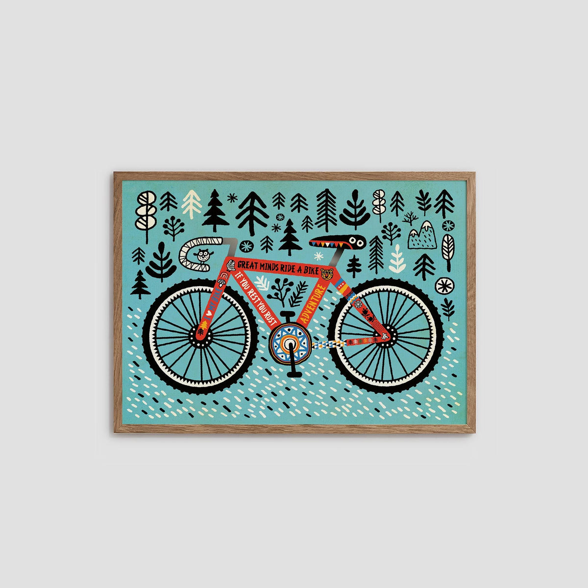 A framed art print featuring a whimsical illustration of an orange bicycle with trees and dots on a turquoise background, shown against a light gray wall.
