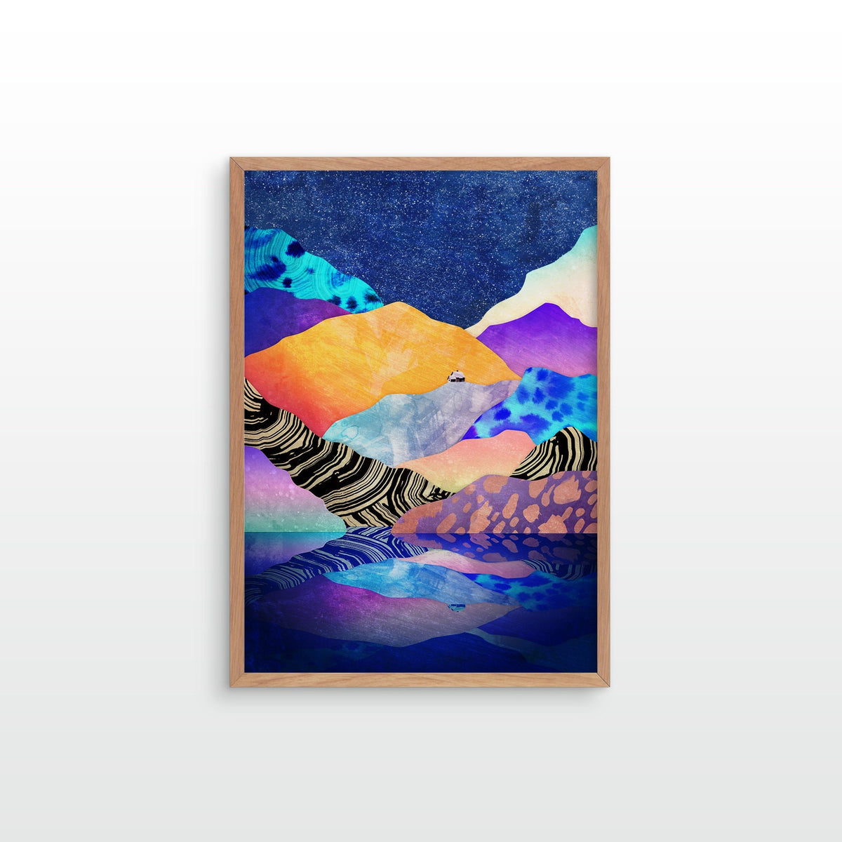 A framed abstract landscape art print featuring colorful mountains and water reflections, displayed on a clean white wall.