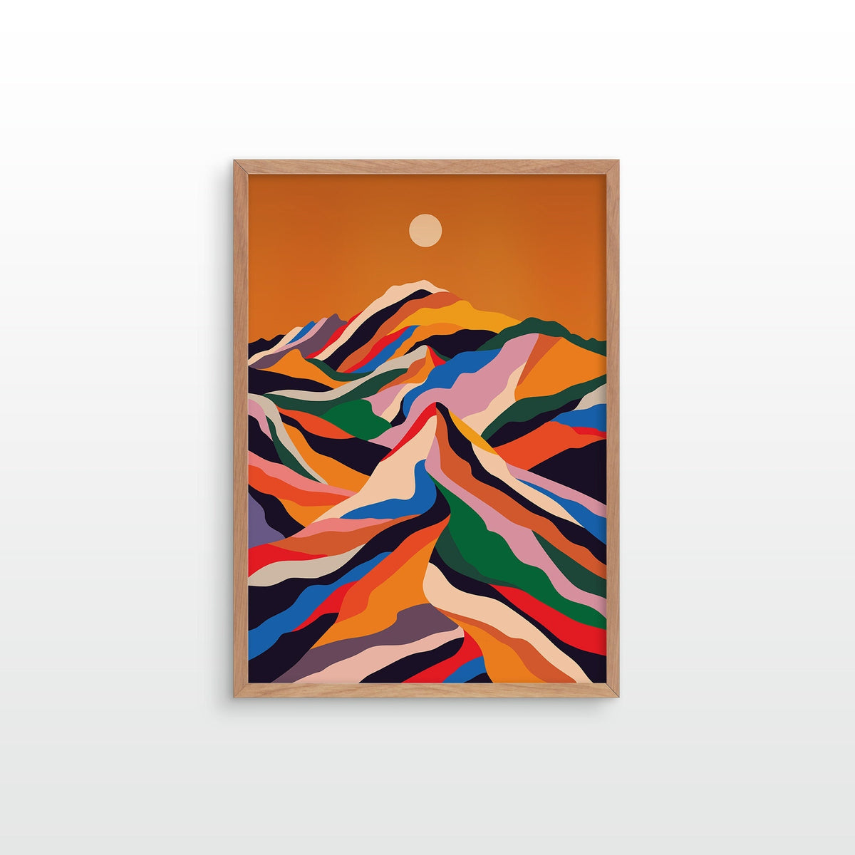 A framed art print featuring a colorful, stylized mountain landscape under an orange sky with a small sun, displayed on a light gray wall.