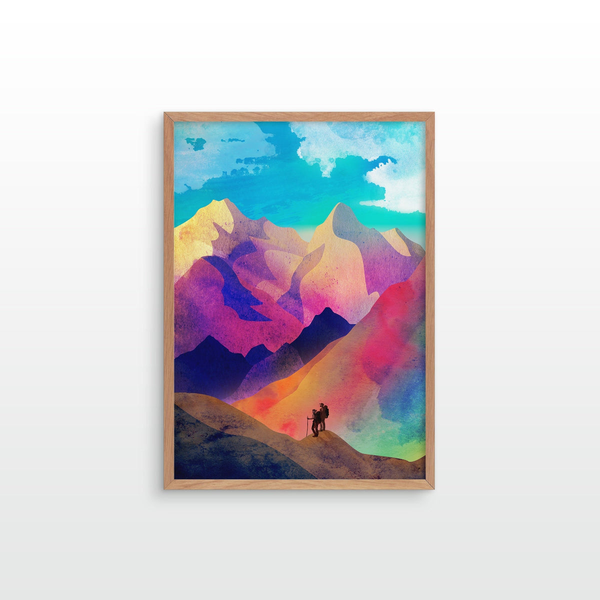 A framed art print featuring a colorful watercolor-style mountain landscape with a small hiker silhouette, displayed against a clean white wall.