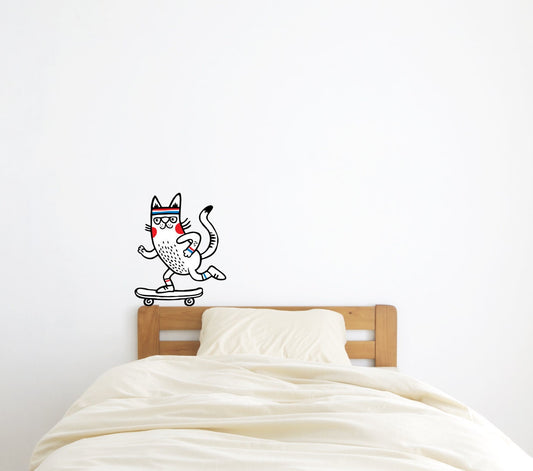 A wall decal of a cartoon cat wearing a red and blue striped hat and riding a skateboard on the wall above the headboard.