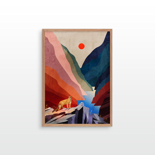 A framed art print featuring a stylized mountain landscape with layered red, pink, blue, and green shapes, a small yellow figure near the bottom, and a red sun in the sky, shown against a light gray wall.