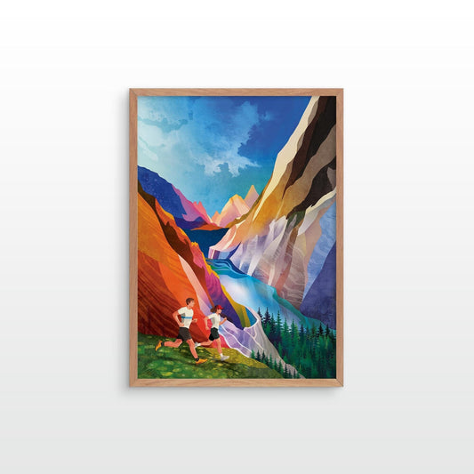 A framed art print depicting a colorful mountain canyon landscape with two runners in the foreground, shown hanging on a light gray wall.